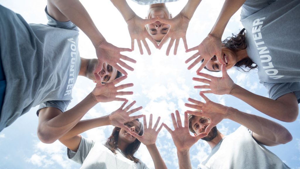 Voluntarios haciendo una estrella con las manos